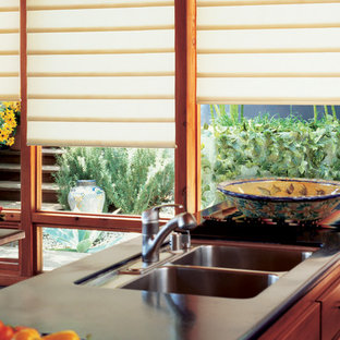Large asian eat-in kitchen ideas - Inspiration for a large asian u-shaped concrete floor and gray floor eat-in kitchen remodel in Dallas with an undermount sink, flat-panel cabinets, medium tone wood cabinets, solid surface countertops, stainless steel appliances and an island