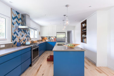 Eat-in kitchen - large eclectic l-shaped light wood floor and multicolored floor eat-in kitchen idea in Vancouver with an undermount sink, flat-panel cabinets, blue cabinets, quartz countertops, multicolored backsplash, ceramic backsplash, stainless steel appliances, an island and brown countertops