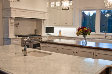 Foto de cocina clásica con fregadero sobremueble, armarios estilo shaker, puertas de armario blancas, encimera de mármol, salpicadero blanco y electrodomésticos de acero inoxidable