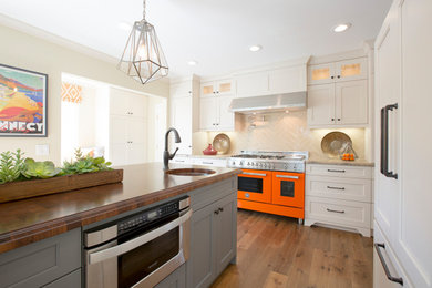 Eat-in kitchen - large contemporary u-shaped medium tone wood floor and brown floor eat-in kitchen idea in Orange County with an undermount sink, shaker cabinets, beige cabinets, marble countertops, beige backsplash, ceramic backsplash, paneled appliances, an island and beige countertops