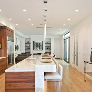 Foto di una cucina moderna di medie dimensioni con lavello sottopiano, ante lisce, ante in legno bruno, top in marmo, paraspruzzi bianco, paraspruzzi in marmo, elettrodomestici in acciaio inossidabile, parquet chiaro, isola e pavimento beige