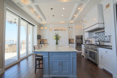 Inspiration for a large u-shaped medium tone wood floor and brown floor open concept kitchen remodel in Orange County with a drop-in sink, shaker cabinets, blue cabinets, marble countertops, white backsplash, subway tile backsplash, stainless steel appliances and an island