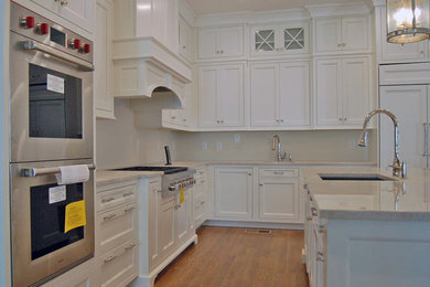 Eat-in kitchen - large traditional l-shaped medium tone wood floor eat-in kitchen idea in Atlanta with an undermount sink, beaded inset cabinets, white cabinets, stainless steel appliances and an island