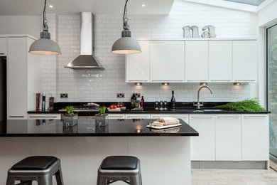 Design ideas for a contemporary kitchen in London with white cabinets, an island, a submerged sink, flat-panel cabinets, white splashback and metro tiled splashback.