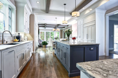 Large elegant u-shaped medium tone wood floor and brown floor eat-in kitchen photo in New York with an undermount sink, shaker cabinets, white cabinets, marble countertops, white backsplash, marble backsplash, stainless steel appliances and an island