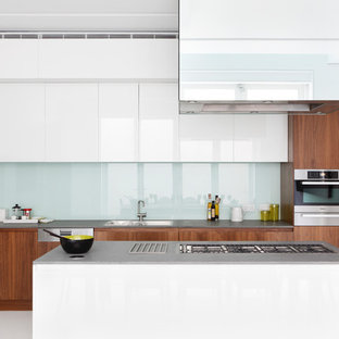 Esempio di una cucina parallela contemporanea con lavello da incasso, ante lisce, ante in legno scuro, paraspruzzi con lastra di vetro, isola, pavimento bianco e top grigio