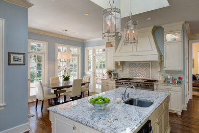 Eat-in kitchen - large traditional l-shaped dark wood floor and brown floor eat-in kitchen idea in Tampa with an undermount sink, raised-panel cabinets, white cabinets, quartzite countertops, gray backsplash, porcelain backsplash, stainless steel appliances and an island