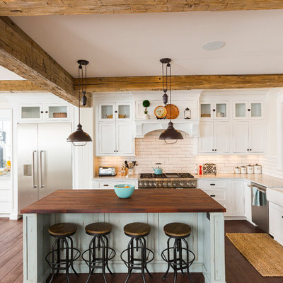 Example of a large farmhouse l-shaped dark wood floor and brown floor eat-in kitchen design in Cincinnati with white cabinets, white backsplash, stainless steel appliances, an island, a farmhouse sink, marble countertops, porcelain backsplash and shaker cabinets