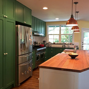 Large contemporary eat-in kitchen ideas - Inspiration for a large contemporary l-shaped medium tone wood floor and brown floor eat-in kitchen remodel in Austin with white backsplash, subway tile backsplash, stainless steel appliances, an island, a farmhouse sink, shaker cabinets, green cabinets and wood countertops