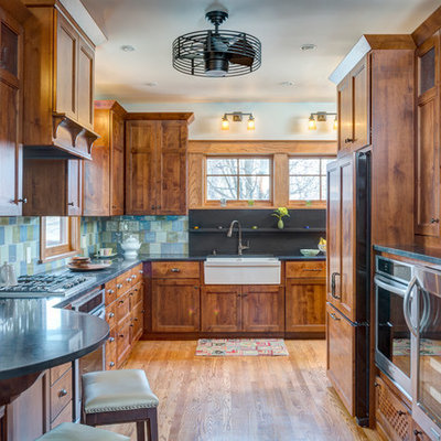 Inspiration for a craftsman medium tone wood floor kitchen remodel in Kansas City with recessed-panel cabinets, medium tone wood cabinets, blue backsplash and stainless steel appliances