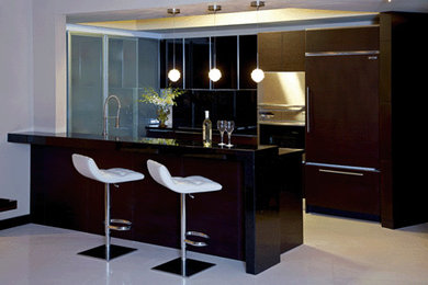 Example of a small trendy u-shaped marble floor eat-in kitchen design in Miami with flat-panel cabinets, dark wood cabinets, granite countertops, black backsplash, stone slab backsplash, stainless steel appliances and a peninsula