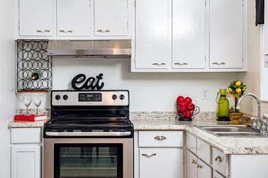 Große Klassische Küche in L-Form mit flächenbündigen Schrankfronten, weißen Schränken, weißen Elektrogeräten, Doppelwaschbecken und Granit-Arbeitsplatte in Orlando
