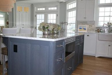 Eat-in kitchen - large modern u-shaped medium tone wood floor and brown floor eat-in kitchen idea in New York with a farmhouse sink, shaker cabinets, white cabinets, marble countertops, gray backsplash, marble backsplash, white appliances and an island
