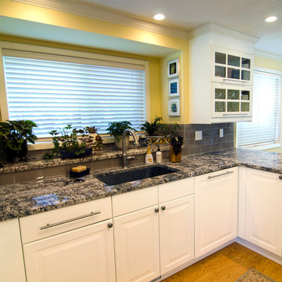 Eat-in kitchen - mid-sized transitional u-shaped light wood floor and brown floor eat-in kitchen idea in Portland with an undermount sink, raised-panel cabinets, white cabinets, granite countertops, gray backsplash, glass tile backsplash, stainless steel appliances, no island and gray countertops