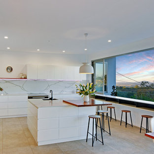 Design ideas for a large contemporary l-shaped open plan kitchen in Sunshine Coast with with island, flat-panel cabinets, white cabinets, white splashback, white benchtop, marble benchtops, marble splashback, stainless steel appliances, a single-bowl sink, porcelain floors and grey floor.