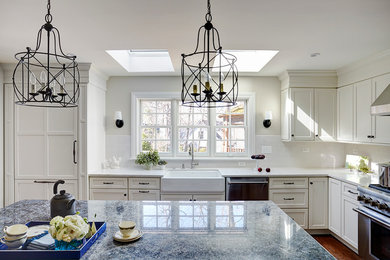 Enclosed kitchen - large traditional l-shaped light wood floor enclosed kitchen idea in San Francisco with a farmhouse sink, flat-panel cabinets, white cabinets, granite countertops, white backsplash, ceramic backsplash, stainless steel appliances and an island