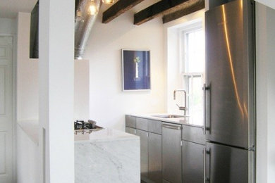 Foto de cocina moderna pequeña sin isla con fregadero bajoencimera, electrodomésticos de acero inoxidable y suelo de madera oscura