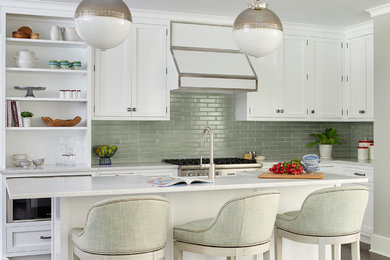 Klassische Küche in L-Form mit Schrankfronten im Shaker-Stil, weißen Schränken, Küchenrückwand in Weiß, Küchengeräten aus Edelstahl, dunklem Holzboden, Kücheninsel, braunem Boden und weißer Arbeitsplatte in Boston