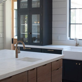 Offene, Große Industrial Küche in U-Form mit Landhausspüle, Schrankfronten im Shaker-Stil, blauen Schränken, Kupfer-Arbeitsplatte, Küchenrückwand in Weiß, Rückwand aus Keramikfliesen, Küchengeräten aus Edelstahl, hellem Holzboden, Kücheninsel und beigem Boden in Jacksonville