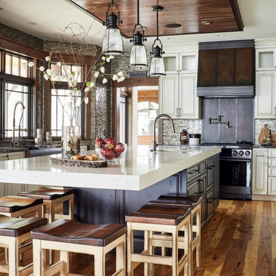 Eat-in kitchen - large rustic u-shaped medium tone wood floor and brown floor eat-in kitchen idea in Other with a farmhouse sink, recessed-panel cabinets, white cabinets, quartz countertops, gray backsplash, an island, white countertops, mosaic tile backsplash and stainless steel appliances