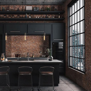 Eat-in kitchen - mid-sized industrial single-wall concrete floor and gray floor eat-in kitchen idea in Columbus with a drop-in sink, flat-panel cabinets, black cabinets, concrete countertops, brown backsplash, brick backsplash, stainless steel appliances, an island and gray countertops