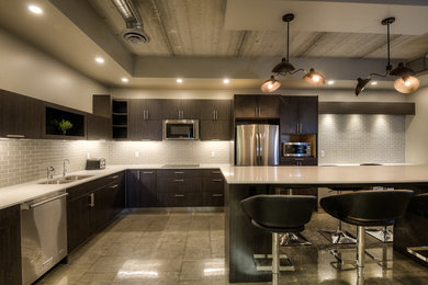 Example of a mid-sized trendy l-shaped concrete floor and gray floor kitchen design in Toronto with a double-bowl sink, flat-panel cabinets, medium tone wood cabinets, quartz countertops, gray backsplash, glass tile backsplash, stainless steel appliances and an island