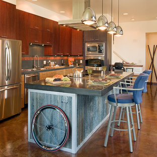 Industrial eat-in kitchen appliance - Eat-in kitchen - industrial l-shaped eat-in kitchen idea in Denver with a drop-in sink, flat-panel cabinets, dark wood cabinets, concrete countertops, multicolored backsplash, stainless steel appliances and ceramic backsplash