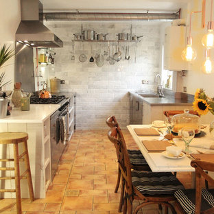 Design ideas for a mid-sized industrial single-wall eat-in kitchen in Hertfordshire with an integrated sink, flat-panel cabinets, distressed cabinets, stainless steel benchtops, stainless steel appliances, ceramic floors and no island.