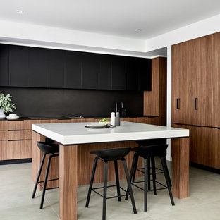 Inspiration for a contemporary l-shaped eat-in kitchen in Sydney with flat-panel cabinets, medium wood cabinets, black splashback, black appliances, with island, grey floor, black benchtop, a double-bowl sink and porcelain floors.