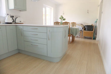 Medium sized classic u-shaped kitchen/diner in Other with a built-in sink, blue cabinets, quartz worktops, white splashback, stainless steel appliances and a breakfast bar.