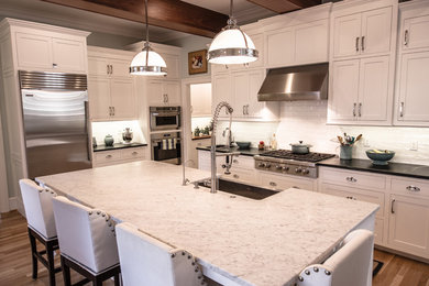 Eat-in kitchen - large eat-in kitchen idea in Wilmington with recessed-panel cabinets, white cabinets, soapstone countertops, white backsplash, stainless steel appliances and an island