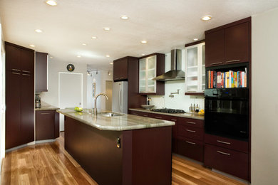 This is an example of a medium sized contemporary l-shaped enclosed kitchen in San Francisco with a submerged sink, flat-panel cabinets, quartz worktops, glass sheet splashback, stainless steel appliances, medium hardwood flooring, an island, brown floors, multicoloured worktops, brown cabinets and white splashback.