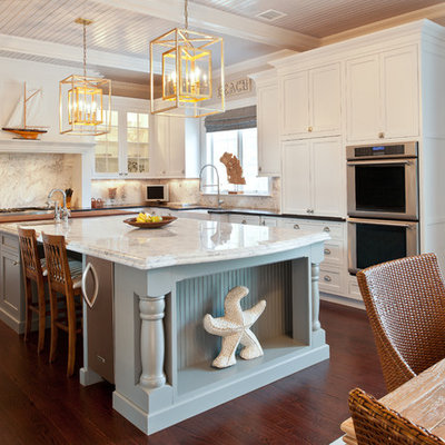Enclosed kitchen - mid-sized traditional u-shaped dark wood floor enclosed kitchen idea in New York with shaker cabinets, a farmhouse sink, white cabinets, marble countertops, white backsplash, stone slab backsplash, stainless steel appliances and an island