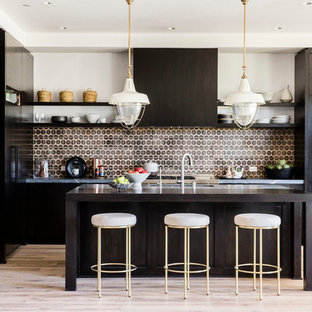 Ispirazione per una grande cucina minimal con paraspruzzi marrone, paraspruzzi con piastrelle in ceramica, ante lisce, ante in legno bruno, parquet chiaro, isola e elettrodomestici in acciaio inossidabile