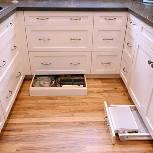 Idée de décoration pour une cuisine américaine tradition en U de taille moyenne avec un évier encastré, un placard à porte shaker, des portes de placard blanches, un plan de travail en quartz modifié, une crédence multicolore, une crédence en carreau briquette, un électroménager en acier inoxydable, un sol en bois clair et une péninsule.
