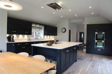 This is an example of a large contemporary kitchen/diner in Other with a submerged sink, shaker cabinets, grey cabinets, quartz worktops, white splashback, stainless steel appliances and an island.