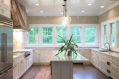 Inspiration for a large country u-shaped medium tone wood floor and brown floor kitchen pantry remodel in Other with an undermount sink, shaker cabinets, white cabinets, quartz countertops, beige backsplash, subway tile backsplash, stainless steel appliances, an island and beige countertops