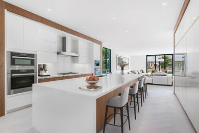 Kitchen - huge contemporary u-shaped gray floor kitchen idea in Miami with an undermount sink, flat-panel cabinets, white cabinets, white backsplash, stainless steel appliances, an island and white countertops