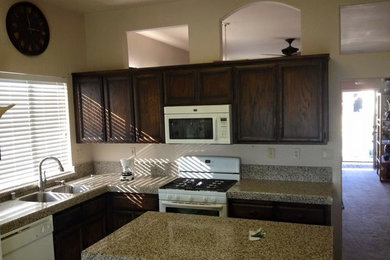 Photo of a medium sized classic l-shaped kitchen in Sacramento with a double-bowl sink, recessed-panel cabinets, dark wood cabinets, granite worktops, white appliances, ceramic flooring and an island.