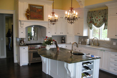 グランドラピッズにある中くらいなおしゃれなキッチン (ドロップインシンク、大理石カウンター、シルバーの調理設備、濃色無垢フローリング) の写真