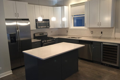Mid-sized trendy l-shaped dark wood floor eat-in kitchen photo in Chicago with a double-bowl sink, recessed-panel cabinets, white cabinets, granite countertops, white backsplash, subway tile backsplash, stainless steel appliances and an island