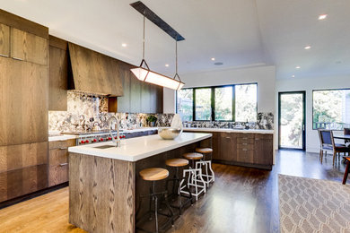 Large trendy l-shaped light wood floor kitchen photo in San Francisco with a drop-in sink, flat-panel cabinets, brown cabinets, quartzite countertops, ceramic backsplash, stainless steel appliances and an island