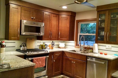 Example of a mid-sized trendy u-shaped kitchen design in Grand Rapids with an undermount sink, shaker cabinets, medium tone wood cabinets, quartz countertops, gray backsplash, porcelain backsplash, stainless steel appliances and no island