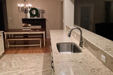 Inspiration for a mid-sized cottage galley marble floor and beige floor enclosed kitchen remodel in Orlando with an undermount sink, shaker cabinets, white cabinets, quartz countertops, beige backsplash, stone slab backsplash, stainless steel appliances and a peninsula