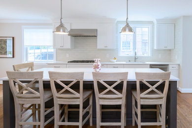 Idéer för att renovera ett vintage vit vitt kök, med en undermonterad diskho, skåp i shakerstil, vita skåp, bänkskiva i kvartsit, vitt stänkskydd, stänkskydd i porslinskakel, rostfria vitvaror, mellanmörkt trägolv, en köksö och brunt golv
