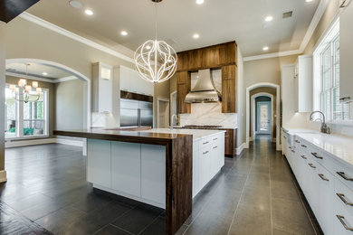 Inspiration for a large contemporary single-wall open concept kitchen remodel in Dallas with a farmhouse sink, flat-panel cabinets, medium tone wood cabinets, marble countertops, stainless steel appliances and an island