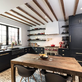 Diseño de cocina comedor en L, campestre, de tamaño medio, sin isla, con fregadero sobremueble, armarios estilo shaker, puertas de armario negras, salpicadero blanco, salpicadero de azulejos tipo metro, electrodomésticos de acero inoxidable, suelo de azulejos de cemento y suelo marrón