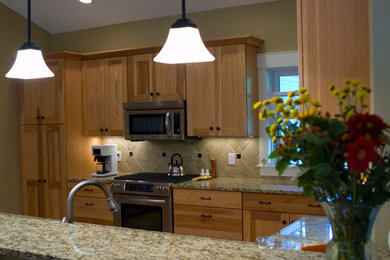 Inspiration for a mid-sized kitchen remodel in Grand Rapids with medium tone wood cabinets, granite countertops and stainless steel appliances