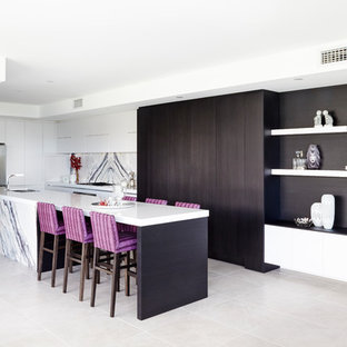 Inspiration for a large contemporary l-shaped kitchen in Sydney with a double-bowl sink, flat-panel cabinets, white cabinets, quartz benchtops, white splashback, stone slab splashback, stainless steel appliances, with island, white benchtop and grey floor.