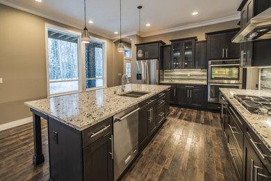Inspiration for a craftsman l-shaped laminate floor and brown floor kitchen remodel in Other with dark wood cabinets, granite countertops and an island